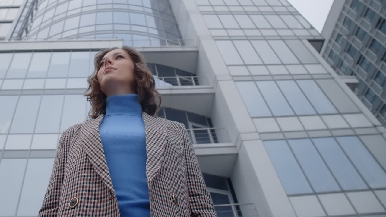 Businesswoman using smartphone in front of high-rise building