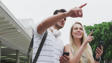 low view of caucasian couple on the go using phone during coronavirus pandemic