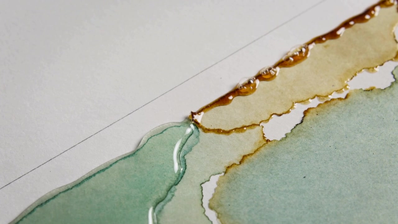 Linea di liquido marrone a contatto e lavatura verde che formano perle arrotondate su carta bianca, con una linea guida a matita.