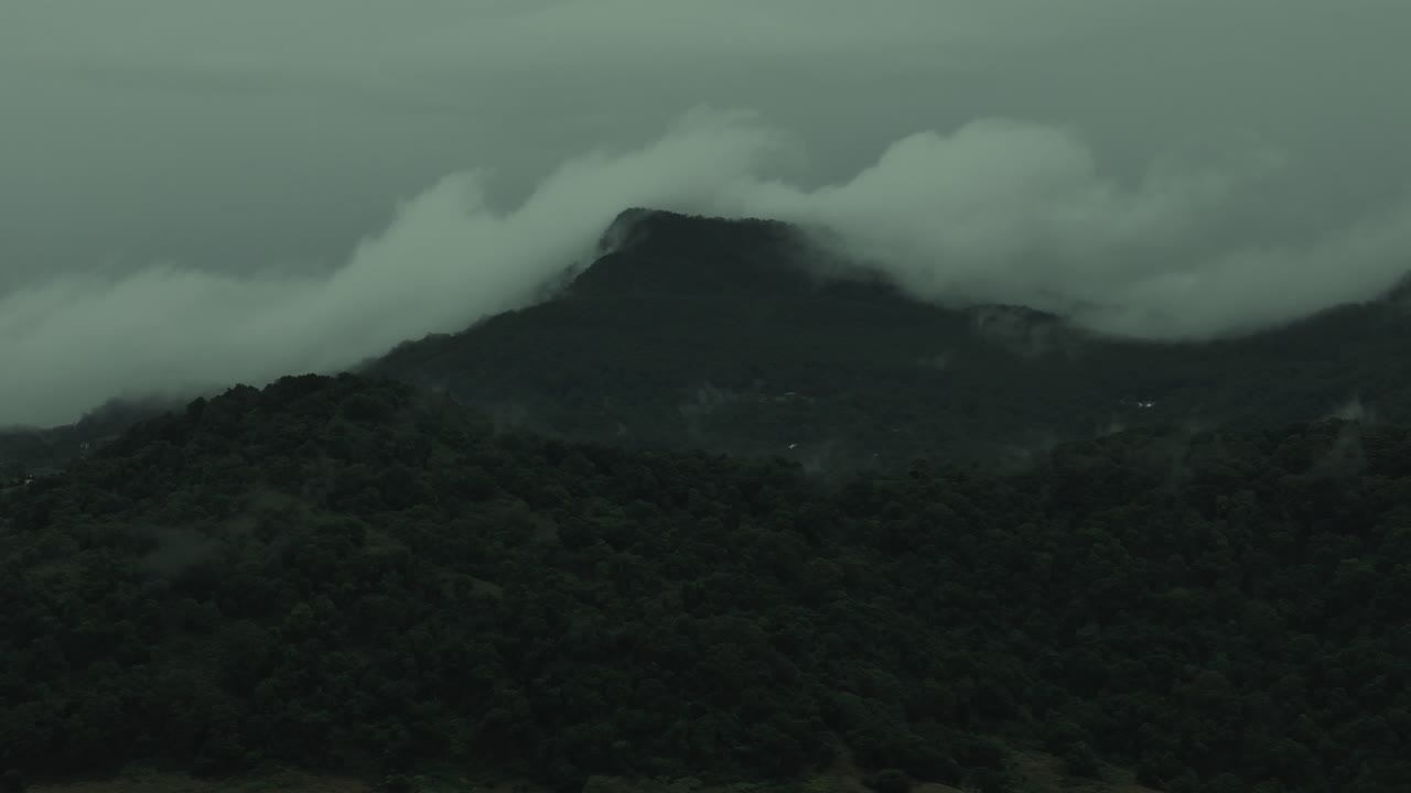 Mount Kembla aerial tracking pan with misty forest slopes, rolling clouds and lush green ridge lines