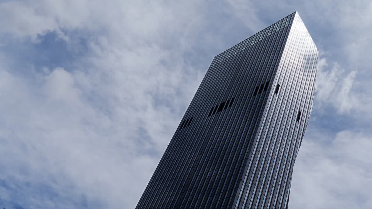 nubes en bucle de 4k por encima de un rascacielos en el lapso de tiempo