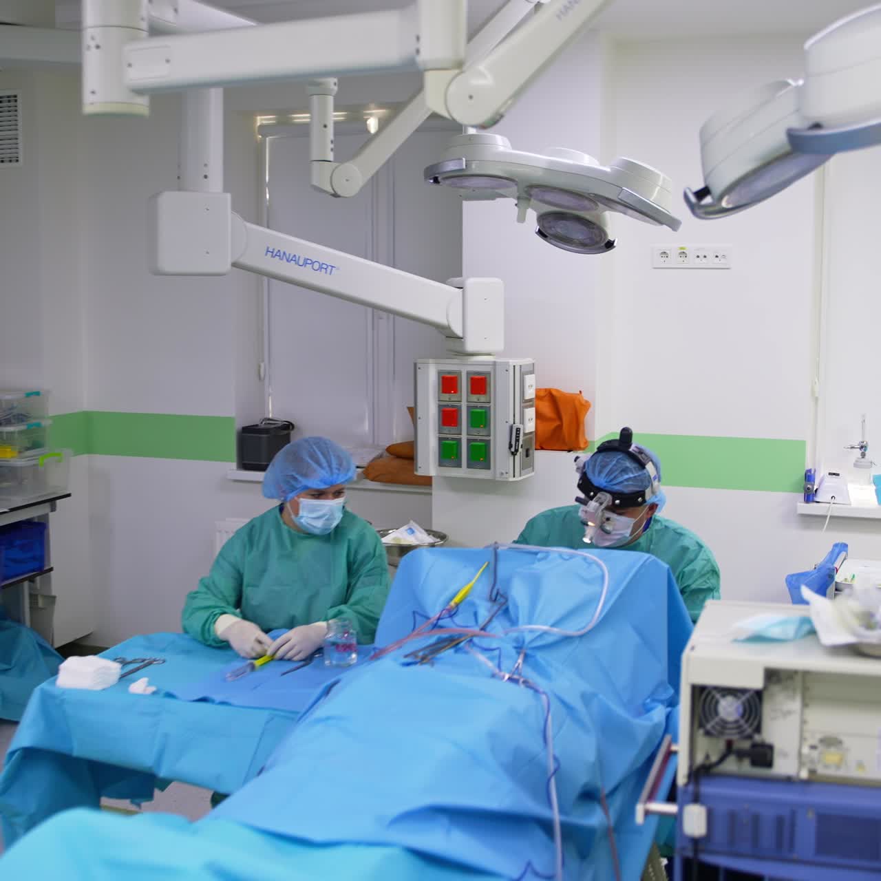 Entering the modern surgery room and approaching quickly the surgeon at work. Nurse sitting beside the doctor in front of table with instruments
