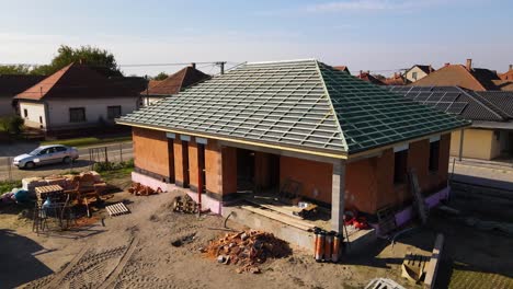 new house under construction with brick walls and roof in strapping phase
