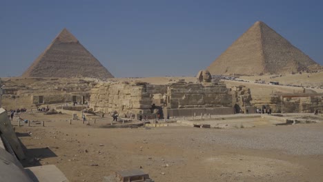 Una-Vista-Fascinante-De-Las-Pirámides-Y-La-Esfinge-De-Giza-Contra-Un-Cielo-Azul-Y-Un-Fondo-Desértico,-Que-Muestra-Maravillas-Antiguas-En-Medio-De-Una-Belleza-Natural-Impresionante