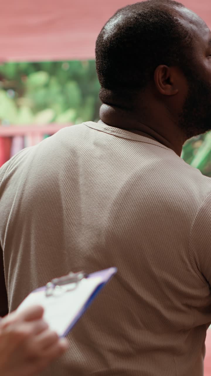 African American Man Talking While Another Person Holds Clipboard