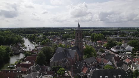 circling aerial view of a church and tower in a dutch village loenen, netherlands