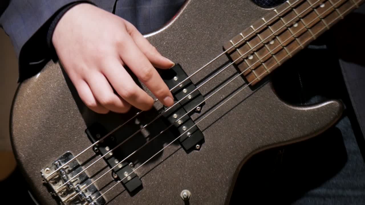 Close-up of bass guitar being played