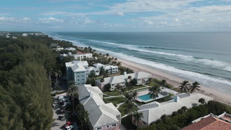 aerial drone shot of hotel and villa in beach resort with sea waves looks in