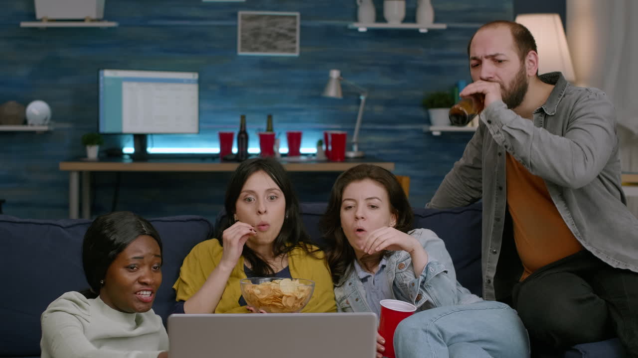 Amici multietnici che trascorrono del tempo insieme guardando un film d'intrattenimento.