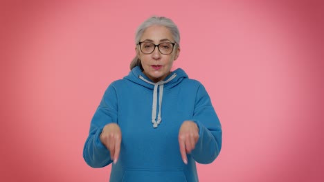 mature old granny woman looking authoritative, fingers down demanding immediate serious conversation