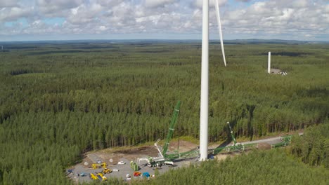 Ascending-orbital-shot-of-wind-turbine-undergoing-maintenance,-construction-site-of-a-wind-turbine-generator