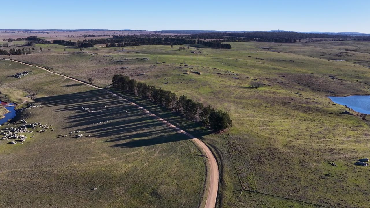 Drone-opname vanuit de hoogte van een landweg en groene weiden in Uralla, Australië