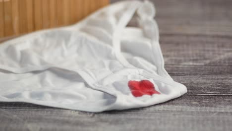 white underwear with period stain on wooden table