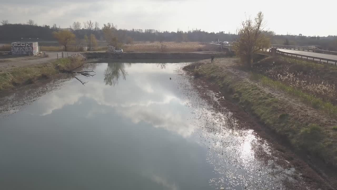 자동차가 순환하는 오른쪽에 도로가 있는 강 위의 드론 비행