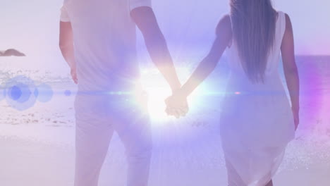 animation of light moving over back view of caucasian newly married couple on beach