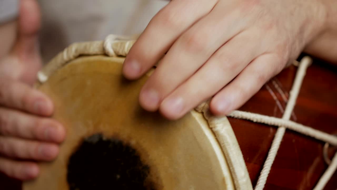cerca de las manos de un hombre tocando un tambor.