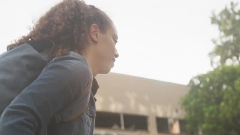 Happy-biracial-woman-in-city,-walking-with-bike