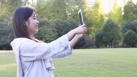 4k: beautiful asian woman listening music under sun flare at park,shanghai,china