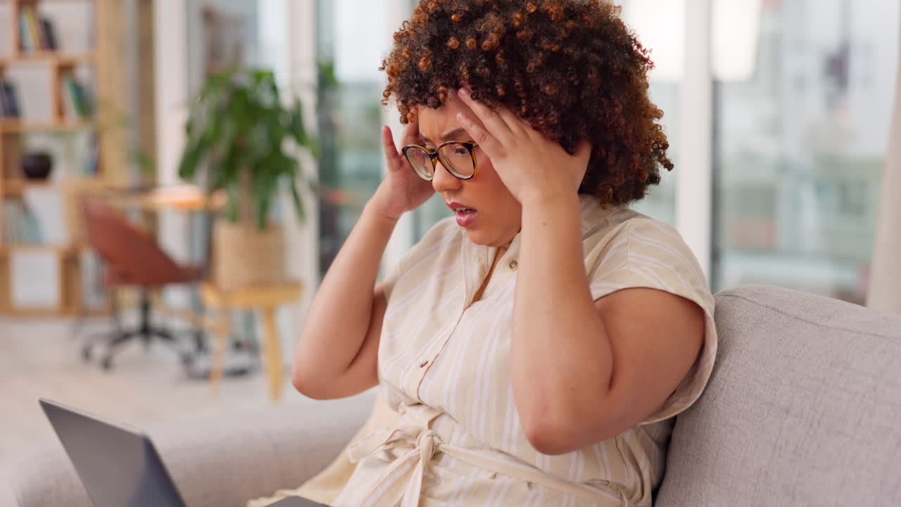Confused, frustrated and woman with laptop on sofa