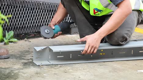 worker using grinder to cut metal beam