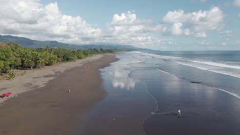 gente jugando en las aguas arenosas y poco profundas de playa linda, una playa escondida en la costa pacífica central de costa rica