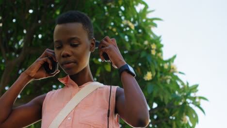 Woman-listening-music-on-headphones-while-checking-time-on-her-smartwatch-4k