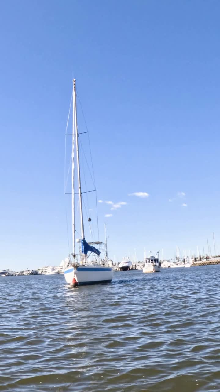 velero moviéndose hacia la ciudad a través de aguas tranquilas