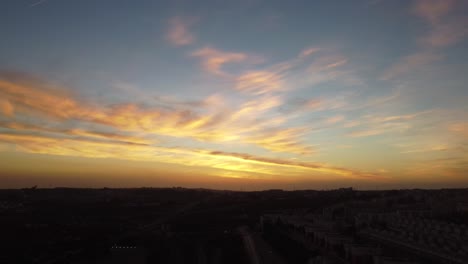 very slow shot on a drone facing an amazing sunset over a city in portugal