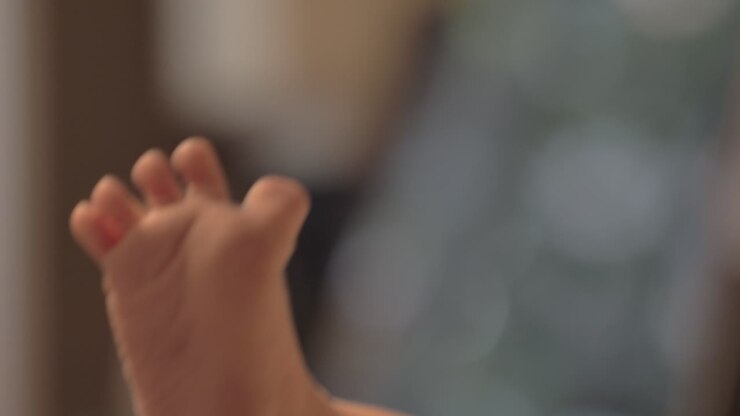 Mum kissing the toes of newborn baby