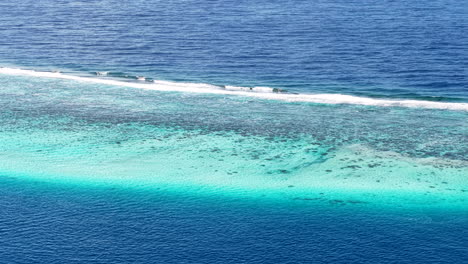 french polynesia, drone shot of coral reefs barrier, waves and lagoon south pacific ocean