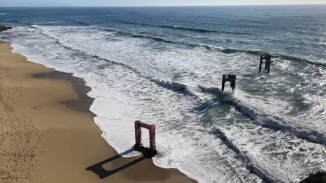 static shot of waves crashing into the famous landmark davenport pier on highway one in northern california