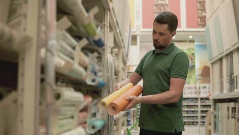 man shopping for wallpaper in a home improvement store