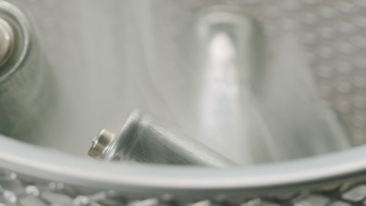 Silver batteries AA and AAA in wastebasket with smoke around close-up. Double-A battery is a standard size single cell cylindrical dry battery. Batteries are common in portable electronic devices. Environmental impacts of lithium-ion batteries concept. An AA battery is composed of a single electroch