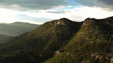 vista aérea de idaho springs, colorado, mostrando las cadenas montañosas boscosas y la suave luz de la tarde