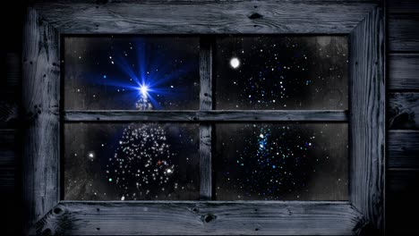 animation of christmas tree and snow falling seen through window