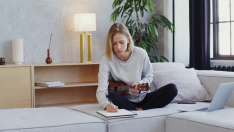 mujer aprendiendo ukulele en casa