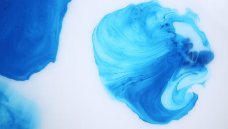 Experimental-shot-of-blue-liquid-getting-dissolved-in-a-white-liquid-due-to-a-chemical-reaction