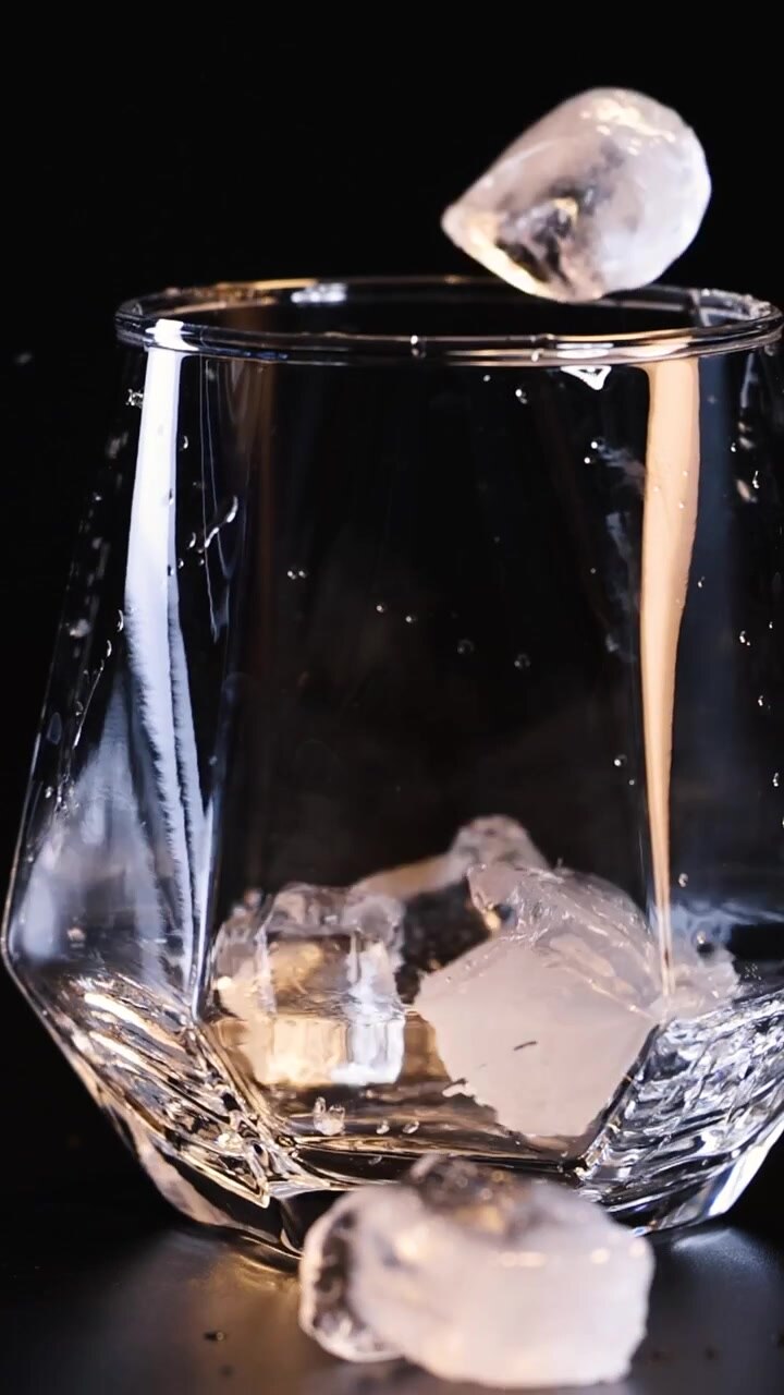 Cubetti di ghiaccio cadono in un bicchiere in sequenza