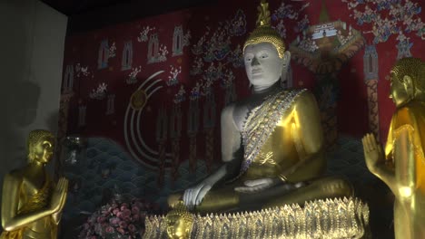 medium of a large thai buddhist statue meditating surrounded by smaller statues