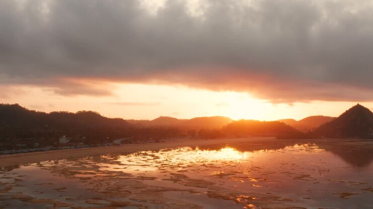 La barriera corallina asciutta di Kuta Lombok all'alba, con la gente del posto che cerca cibo e conchiglie