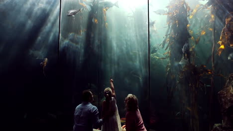 Familia-Feliz-Mirando-Peces-En-El-Tanque