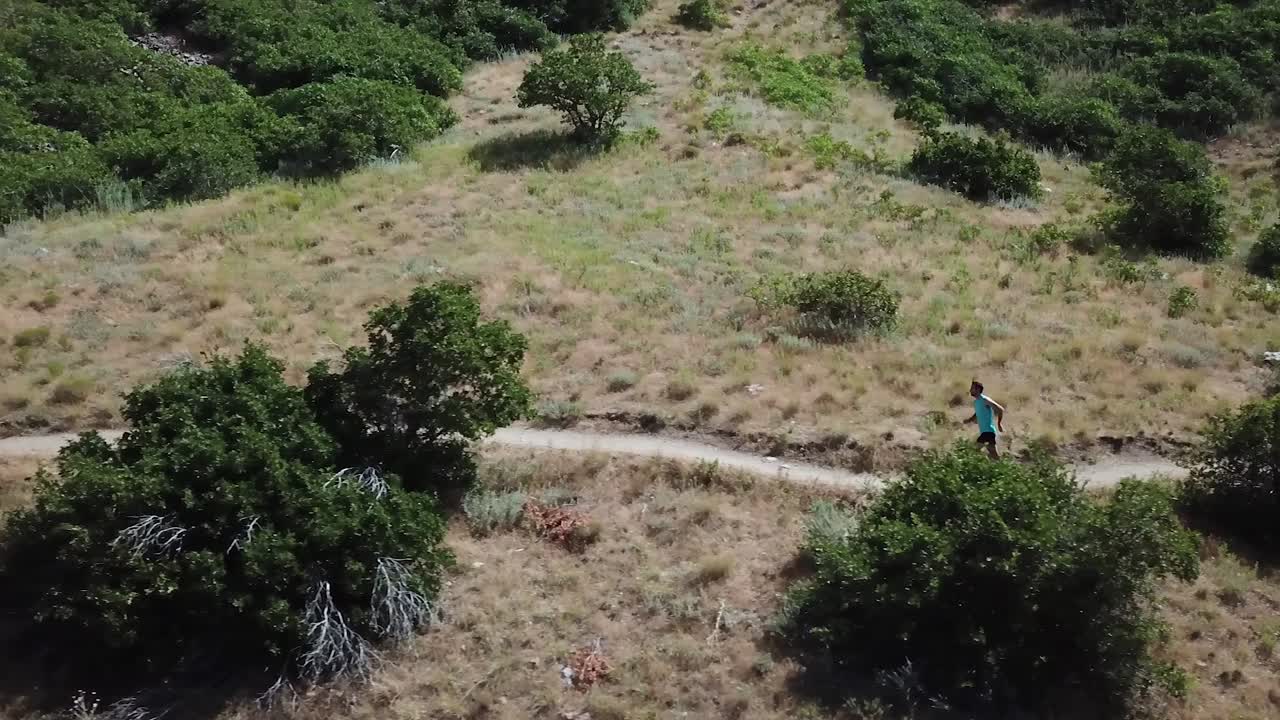 disparo de dron siguiendo a un hombre activo corriendo en los senderos de montaña al aire libre de wasatch sobre draper city, utah-2