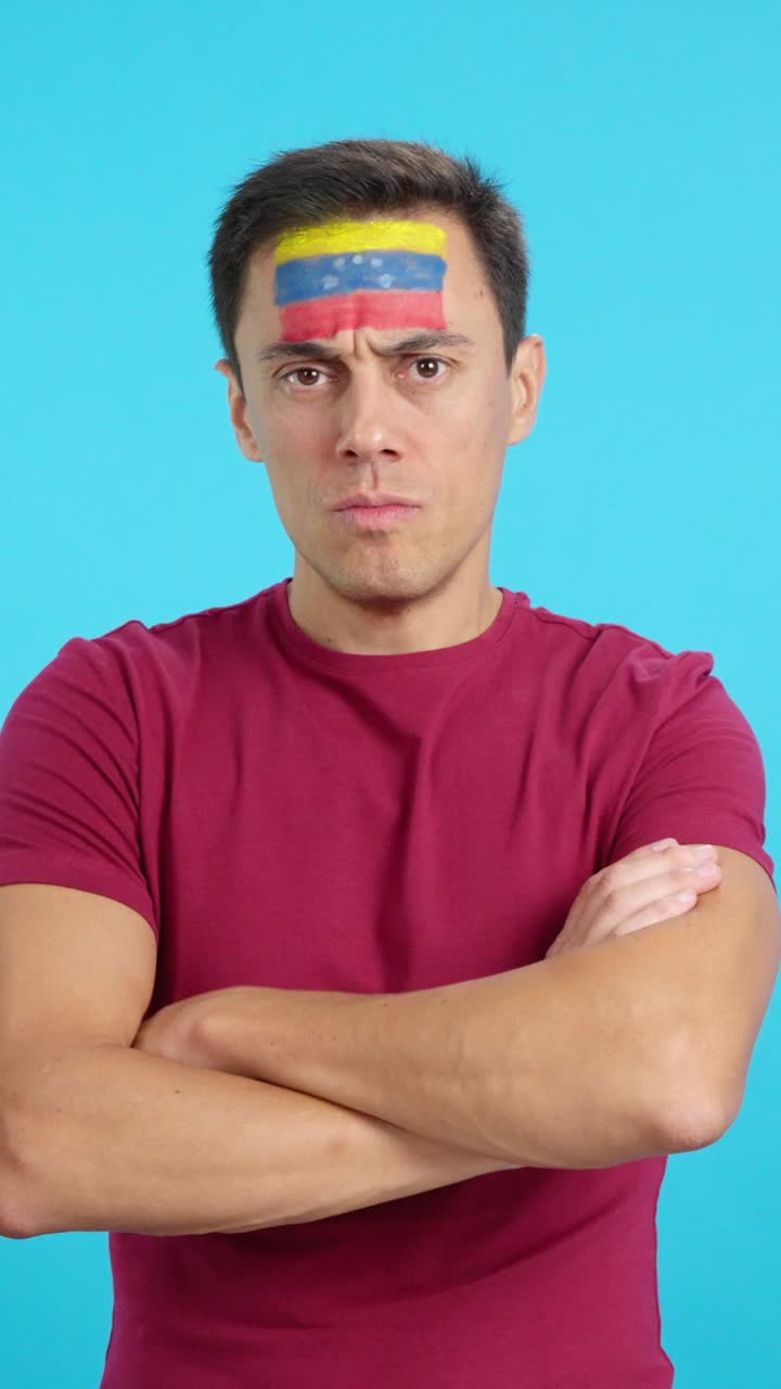 Dignified and serious man with venezuelan flag painted on face