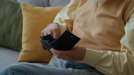 elderly man checking his empty wallet