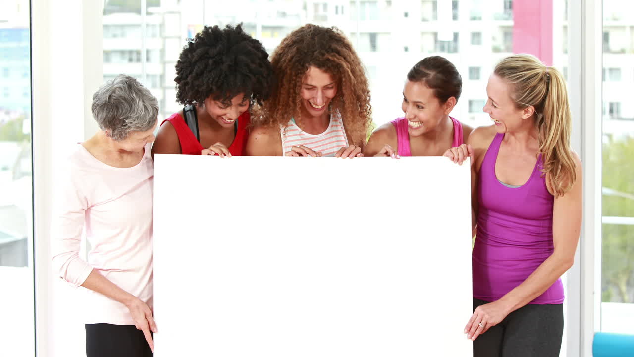 미소 짓는 운동선수 여성들이 복사 공간을 가리키고 있습니다.