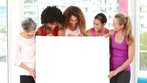 mujeres atléticas sonrientes apuntando a un espacio de copia