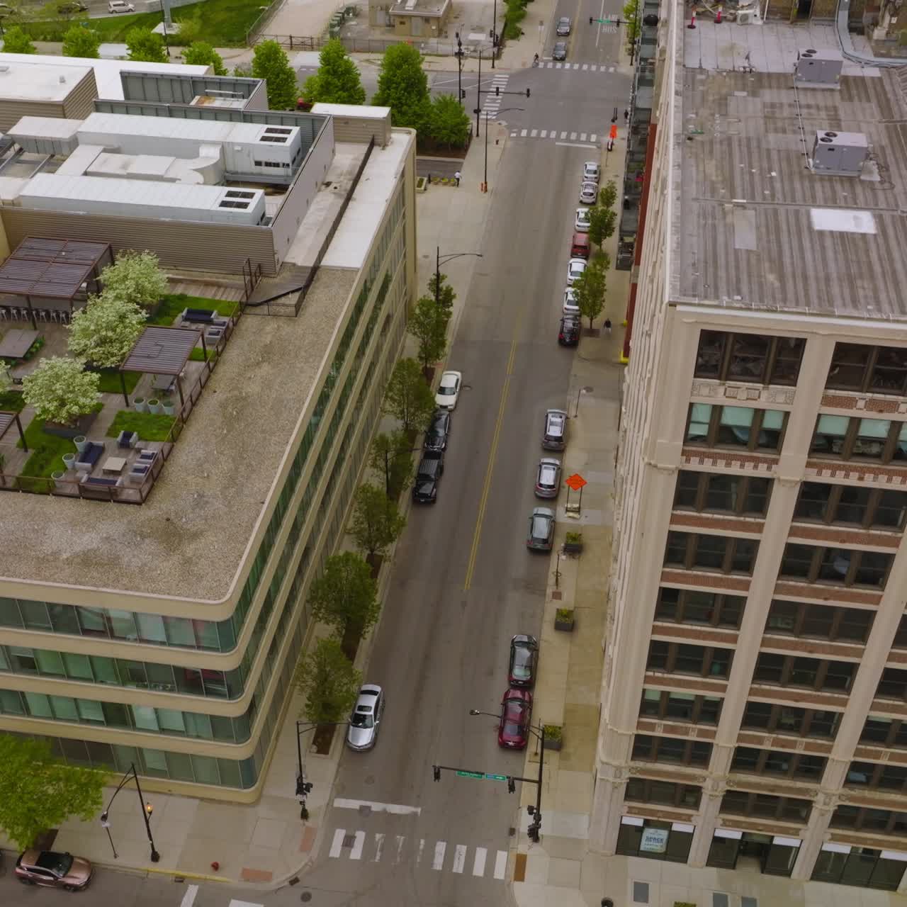 Amazing tops of Chicago buildings with green lounge zones at the roofs. Residential area at daytime. Aerial view