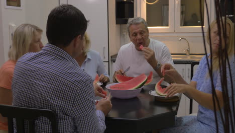 gran familia comiendo sandía en la cocina