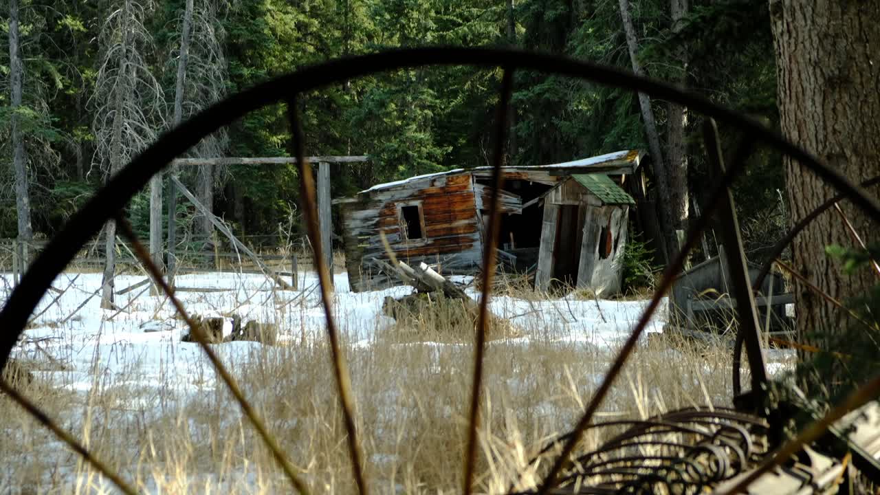 Antique hay rake. tilt shot with old barn in background.