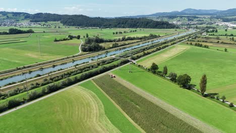 vast green fields, waterways, and a road stretching into the distance, aerial view